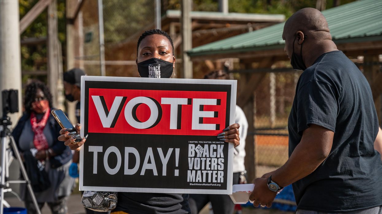 Black voter holds sign urging people to 'VOTE TODAY'