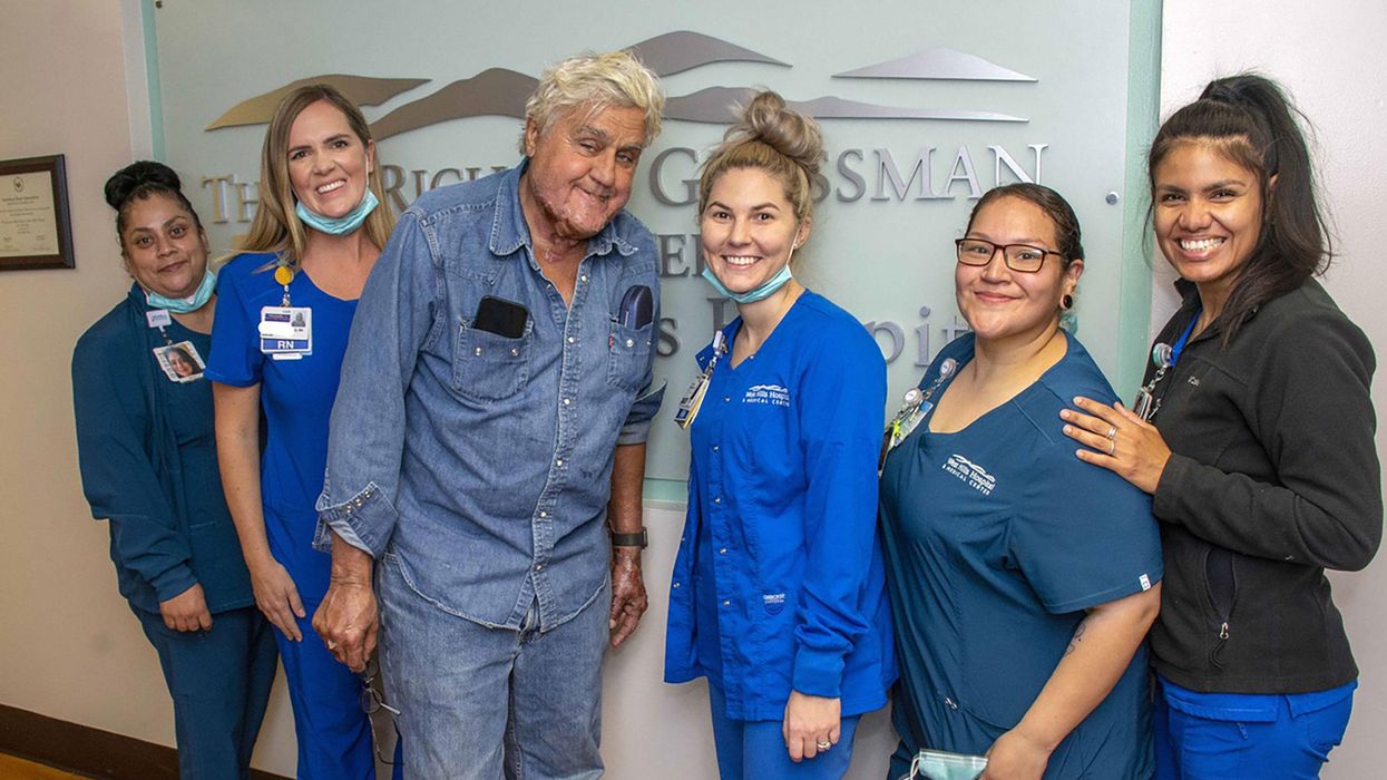 Jay Leno has been discharged from the hospital after sustaining burn injuries in a gasoline fire. Leno is seen here with the staff of the Grossman Burn Center on November 21.