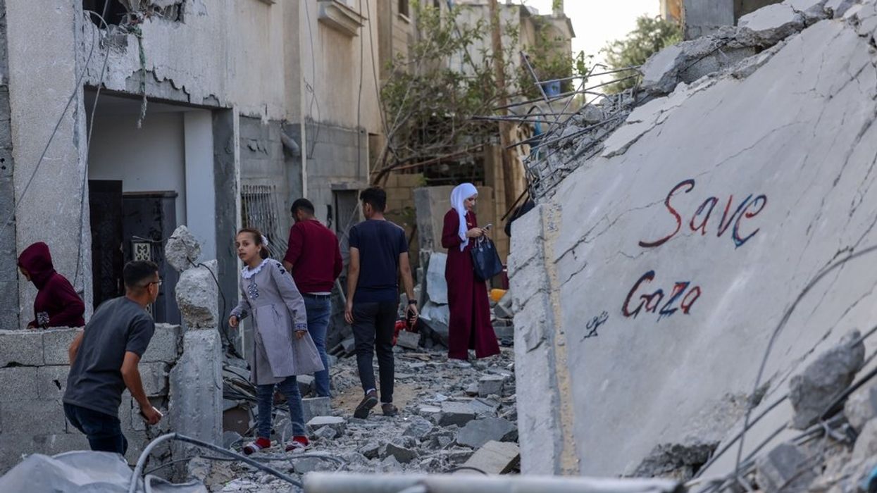 Palestinians inspect the rubble of a house hit by an Israeli air strike