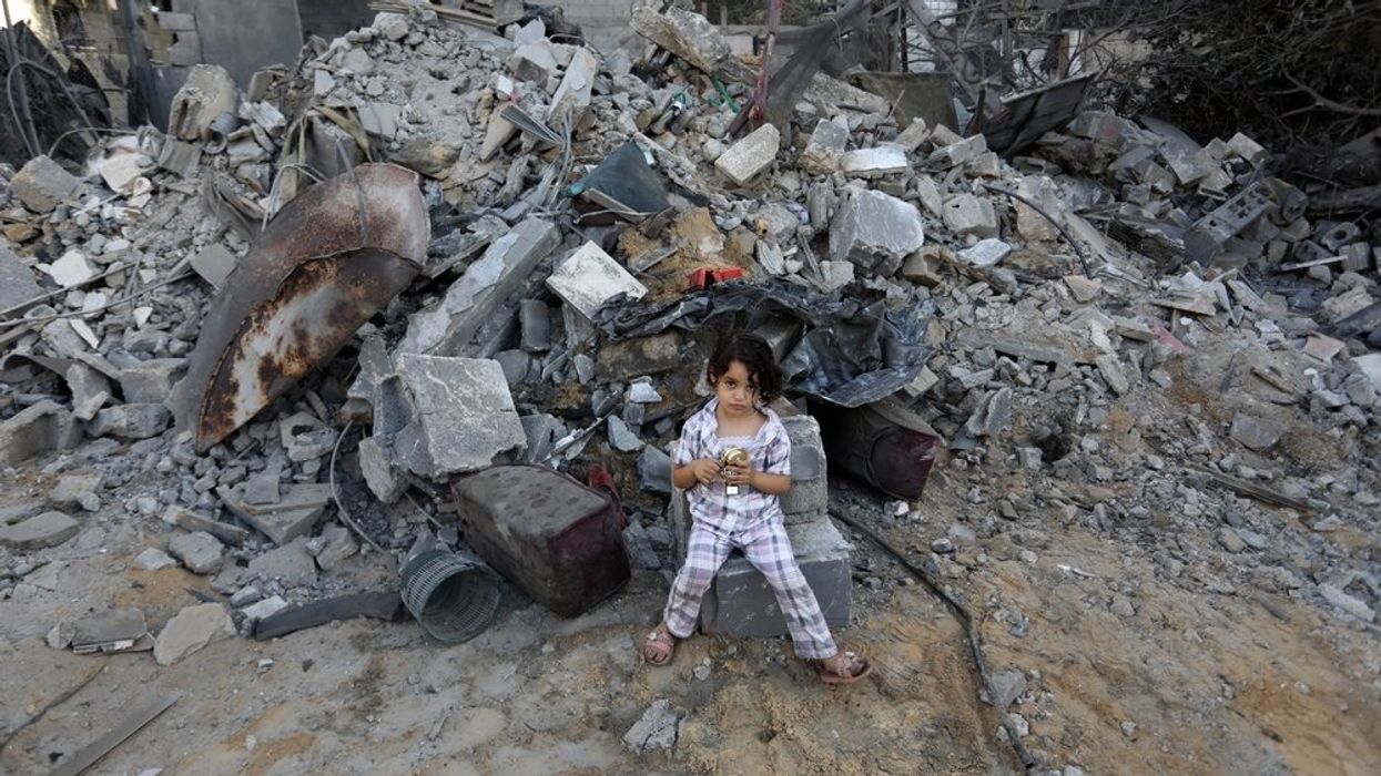 Palestinians inspect their destroyed house