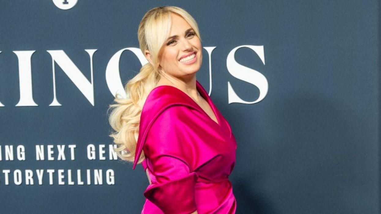 Rebel Wilson poses in pink on a red carpet.